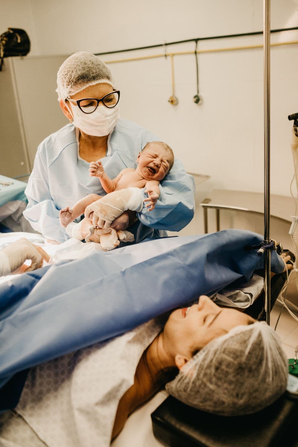 A healthcare professional carefully holding a newborn baby in a hospital