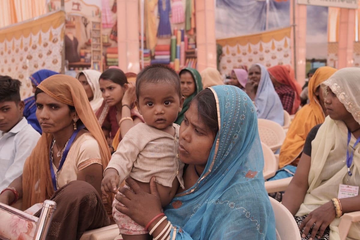 South Asian mothers in colorful dupattas gathered together at a community event